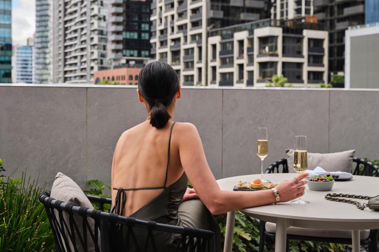 Melbourne Marriott Hotel Docklands Bagian luar foto A woman sitting on a balcony
